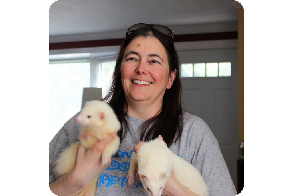 Holding two white ferrets. 