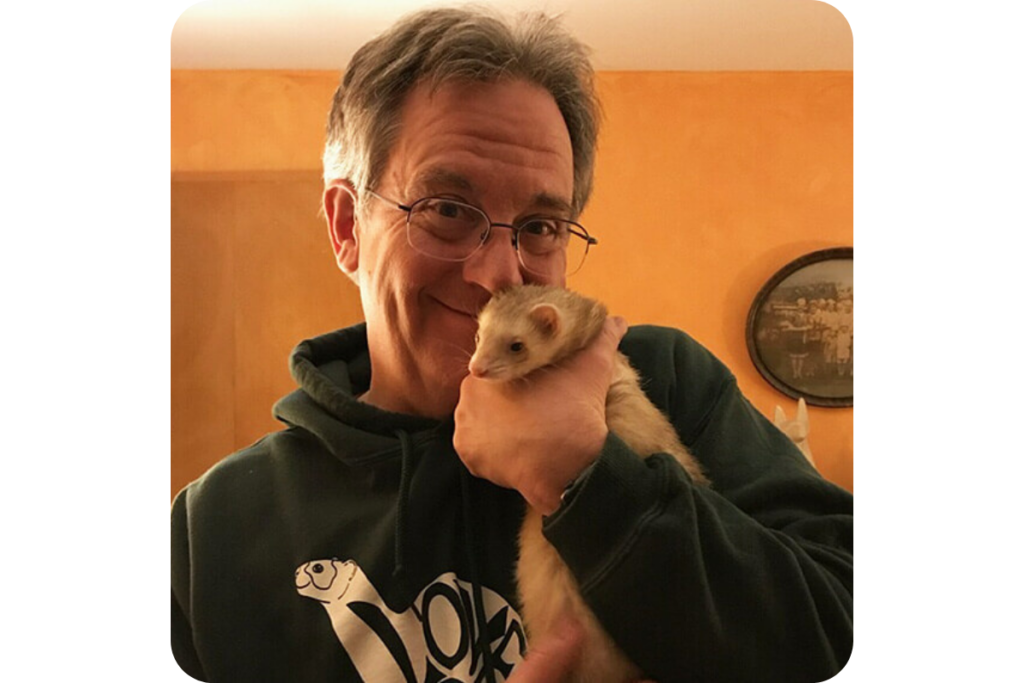 Holding a ferret affectionately.